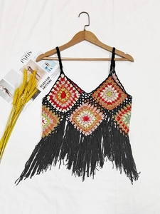 Detail of colorful boho crochet halter top featuring granny squares and long black fringe