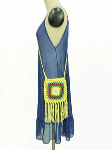 Detail of yellow handmade crochet shoulder bag with colorful circles and long tassels