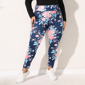 Detail shot of women's high-waisted floral leggings with pink blossoms on navy blue