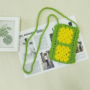 Detail of hand-woven crochet mobile phone bag with bright green yarn and yellow sunflowers