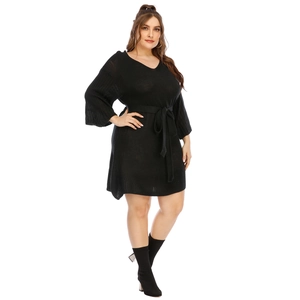 Plus size black V-neck knit dress with flared sleeves and a belted waist shown on model