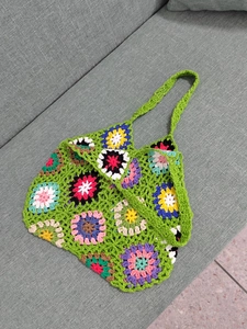 Detailed view of handmade granny square crochet tote with colorful flower patterns