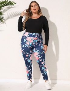 Detail of floral print leggings with pink blossoms on dark blue fabric and rib knit top