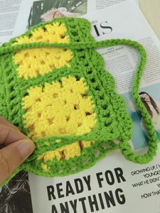 Close-up of handmade crochet bag detail with yellow and green floral woven patterns