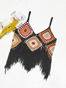 Macro detail of handmade granny square crochet top with long black fringe tassels