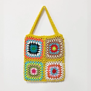 Close-up of vibrant handmade granny square crochet shoulder bag with colorful patterns