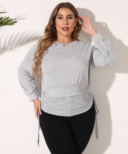 Detail of the adjustable side drawstring and ruched waist on light grey sweatshirt