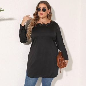 Detail of scalloped hollow neckline on a black long-sleeve tunic for women