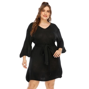 Detail of V-neckline and flare sleeves on black knit dress with waist tie belt