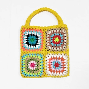Detailed view of colorful crochet granny square stitches and handmade knit texture on the bag