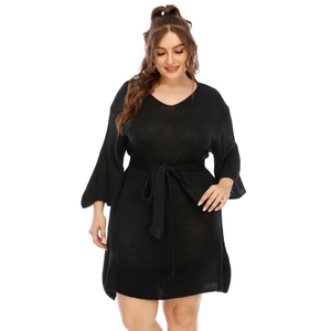 Macro detail of black knit dress texture with flare sleeves and adjustable waist tie belt
