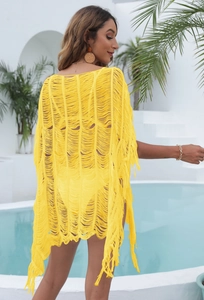 Close-up of vibrant yellow crochet beach cover-up with tassel trim and hollow knit details