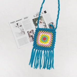 Detailed handmade crochet bag showing multi-color square pattern with long blue fringes