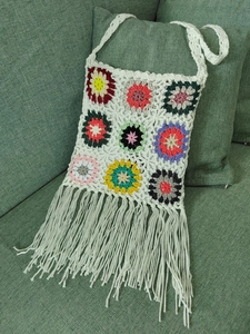 Detailed close-up of handmade crochet tote bag featuring colorful boho tassel fringes