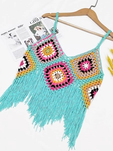 Detail of colorful crochet patchwork top featuring long fringe trim and boho style