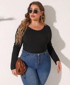 Detail eines schwarzen Langarm-Bodys mit Rippstruktur kombiniert mit Jeans und Accessoires