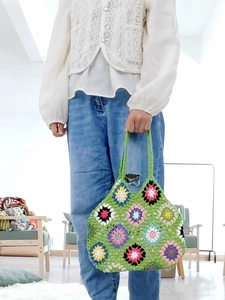 Detail of handmade granny square crochet tote bag with colorful floral knit patterns