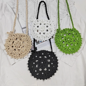 Detail of crochet flower round crossbody bags with pearl beads in multiple colors