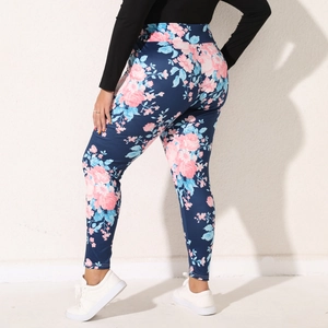 Detail of high-waisted leggings with pink rose floral print on a navy blue background