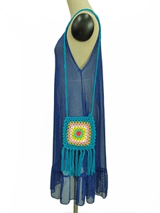 Detail of bohemian handmade crochet bag with long fringe and floral knit pattern
