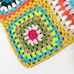 Macro detail of colorful handmade crochet granny square with vibrant knit patterns