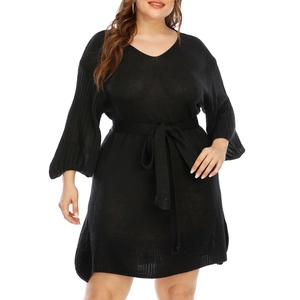 Detail of plus size black knit dress featuring V-neckline and flared sleeves with waist tie