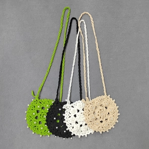Flat lay of colorful crochet mini bags with hollow floral patterns and pearl decorations