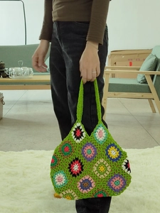 Detailed close-up of handmade crochet tote bag featuring colorful floral knit patterns