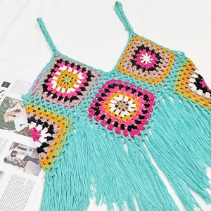 Detail of bohemian crochet fringe top showing colorful handmade knit patterns and texture