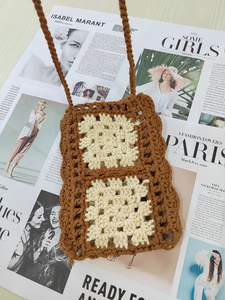 Detail view of handmade crochet mobile phone bag with brown and beige square patterns