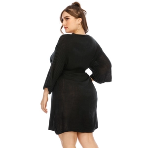 Detail of plus size black knitted dress showing batwing sleeves and waist tie back view