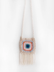 Detail of bohemian handmade crochet crossbody bag with colorful round pattern and fringes
