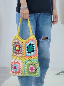 Detail of colorful hand-crocheted granny square pattern on a bohemian shoulder bag