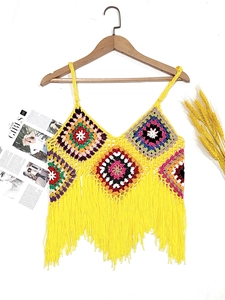 Macro detail of Bohemian granny square crochet top with vibrant tassels and yellow knit texture
