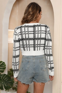 Vue de dos du mannequin portant un gilet en tricot à carreaux noir et blanc et un short