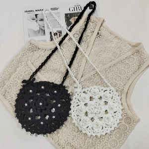 Detail of handmade crochet mini bags featuring floral texture and pearl embellishments
