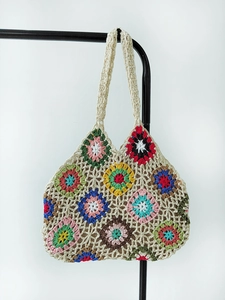 Detail of handmade crochet tote bag featuring multi-colored granny square floral patterns