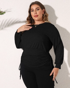 Detail of black long-sleeve top showing slim fit cut and side ruched waist texture