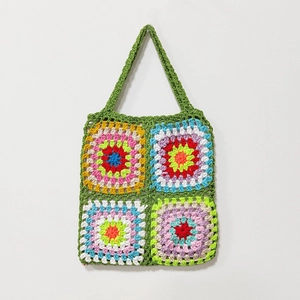 Detail of vibrant handmade crochet granny square tote bag with colorful patchwork pattern