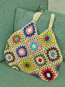 Detailed close-up of handmade crochet tote bag featuring colorful granny square floral patterns