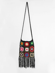 Macro view of handmade crochet bag featuring colorful granny square patterns and fringe detail
