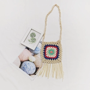 Detailed macro view of colorful crochet granny square bag with long decorative tassels