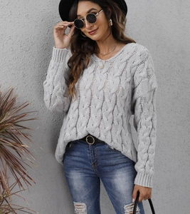 Detail of grey cable knit hooded sweater showing V-neck and thick braided texture
