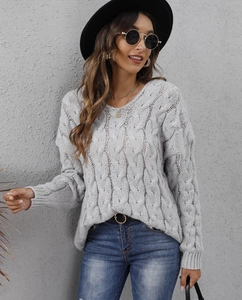 Detailed view of light gray cable knit texture on a chunky V-neck hooded sweater