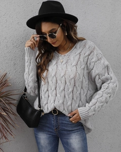 Detail of grey cable knit texture and ribbed cuffs on thick V-neck women sweater