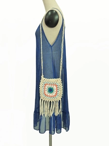 Detail view of handmade crochet granny square crossbody bag with long bohemian tassels