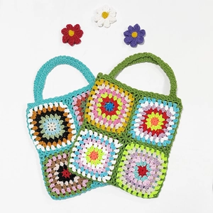 Handmade granny square crochet tote bag in colorful bohemian patchwork style with dual handles