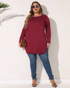 Detail view of burgundy plus size top with laser-cut neckline and side slit hem design