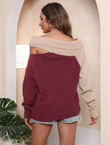 Dettaglio maglione in maglia bordeaux e beige con spalla scoperta e texture a coste fini