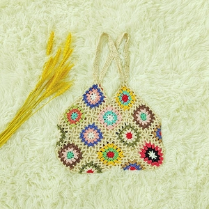 Detailed macro view of colorful granny square patterns on a handmade crochet shoulder bag